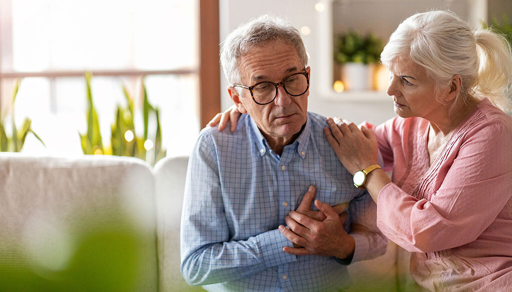 A Senior Man Holding His Chest in Pain With a Senior Woman Beside Him Comforting Him Are Aneurysms Hereditary